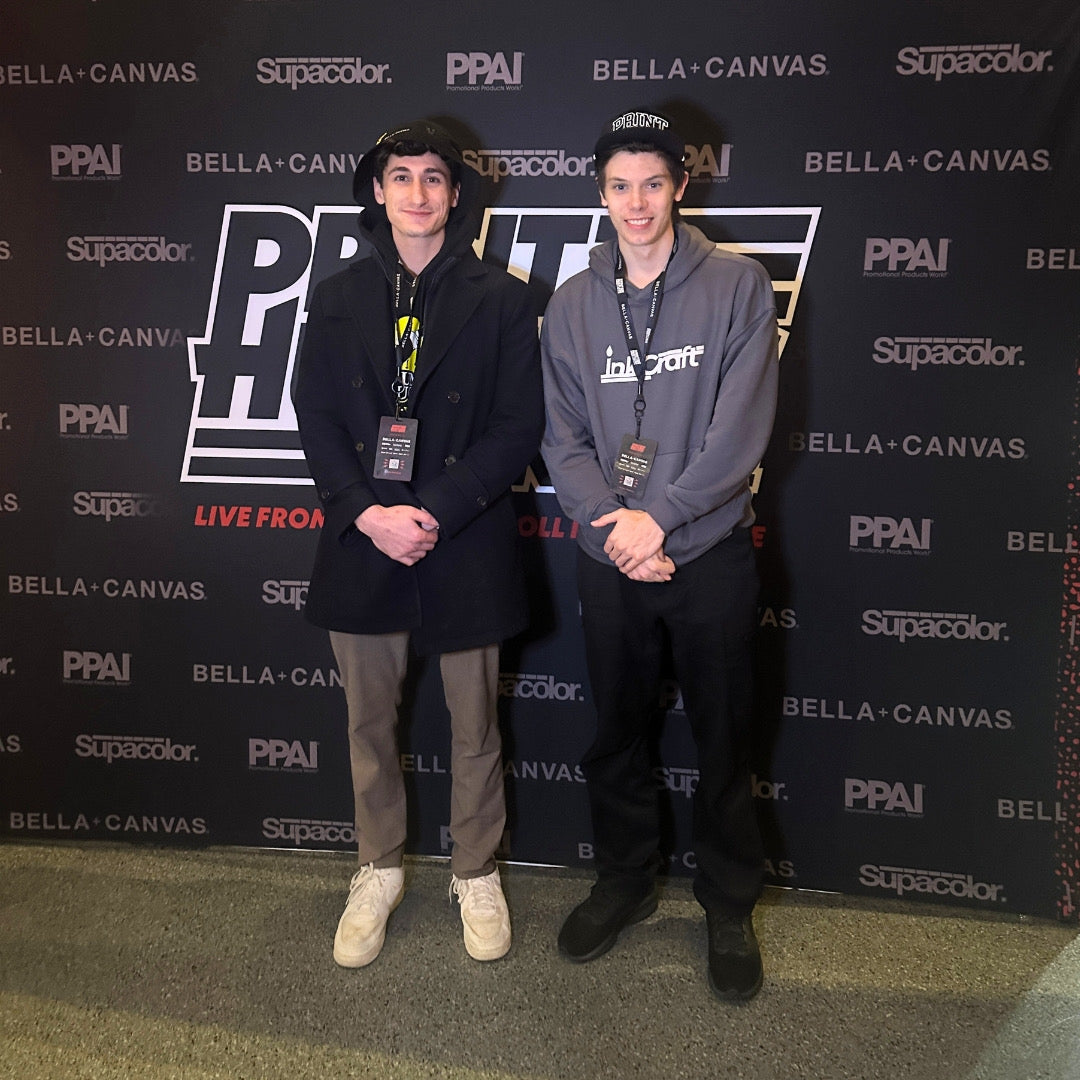 Two InkCraft team members at a trade show, one in an InkCraft hoodie