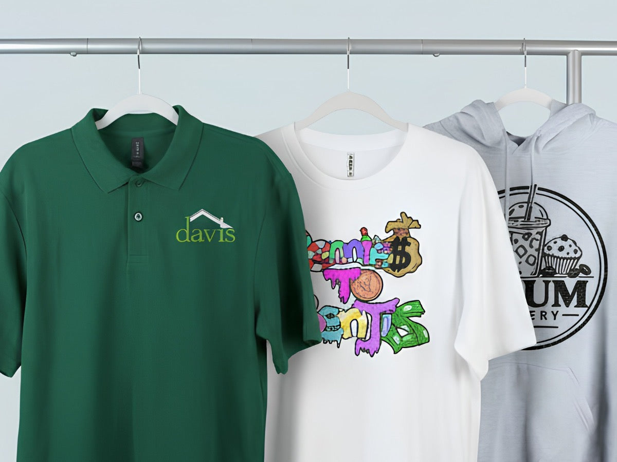 A custom-printed polo, t-shirt and hoodie on hangers on a clothing rack.