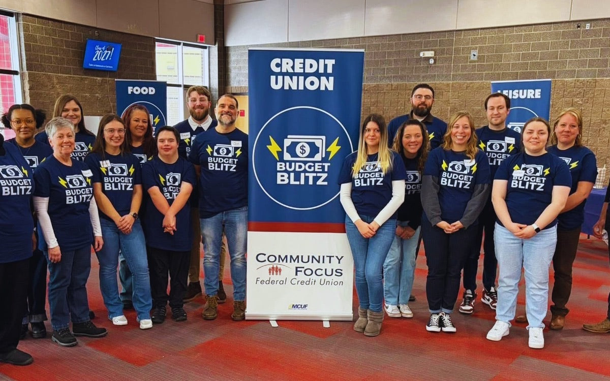 A team in matching custom printed navy t-shirts posing together at a community event