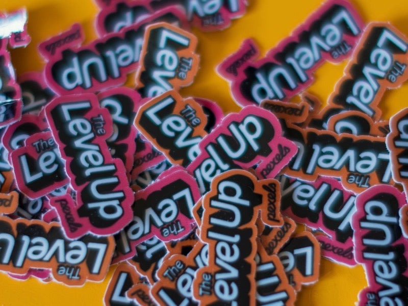 A pile of matching die-cut logo stickers on a yellow table.